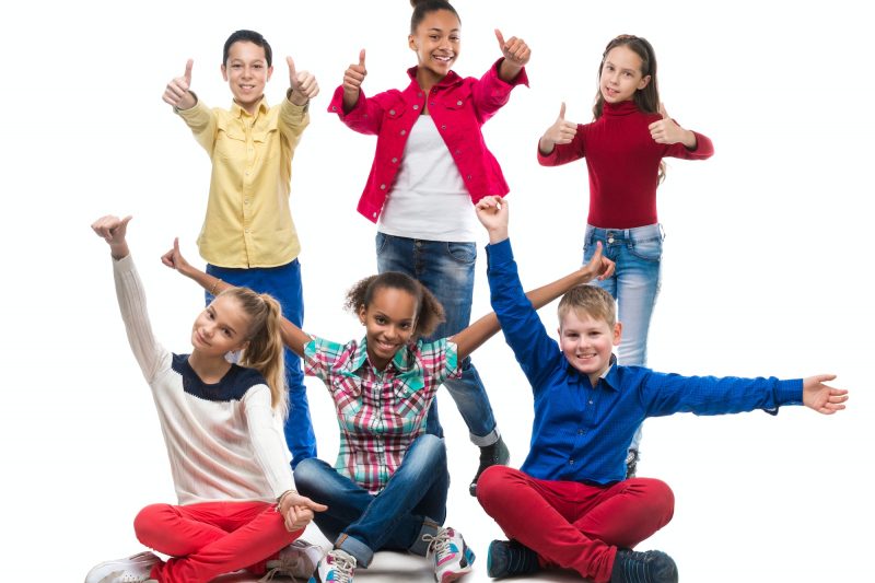 teenagers sitting and standing with thumbs up